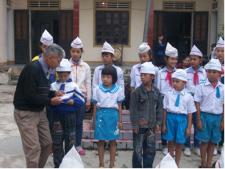 Thầy giáo Hoàng Xuân Liên - Phó chủ tịch hội Khuyến học huyện trao quà cho các cháu trường THCS Diễn Lợi